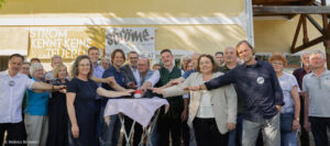 viele Menschen drücken gemeinsam auf einen roten Buzzer und feiern damit die Inbetriebnahme der 1. ströme PV-Anlage